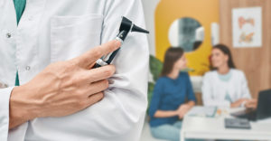 A doctor getting ready to perform a hearing exam.